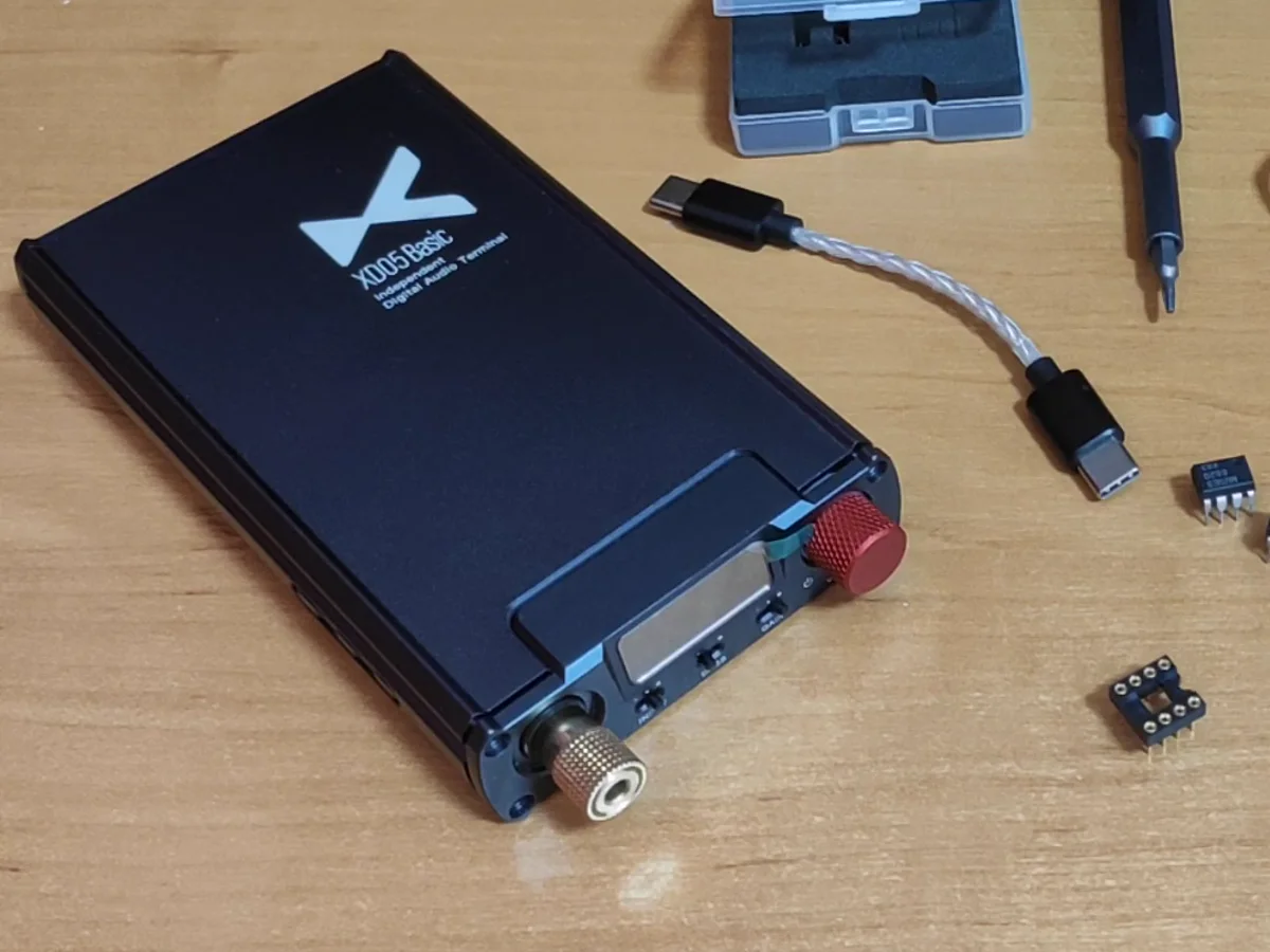 xDuoo XD-05 Basic на столе: красная ручка громкости, золотой разъём для наушников, рядом кабель USB-C