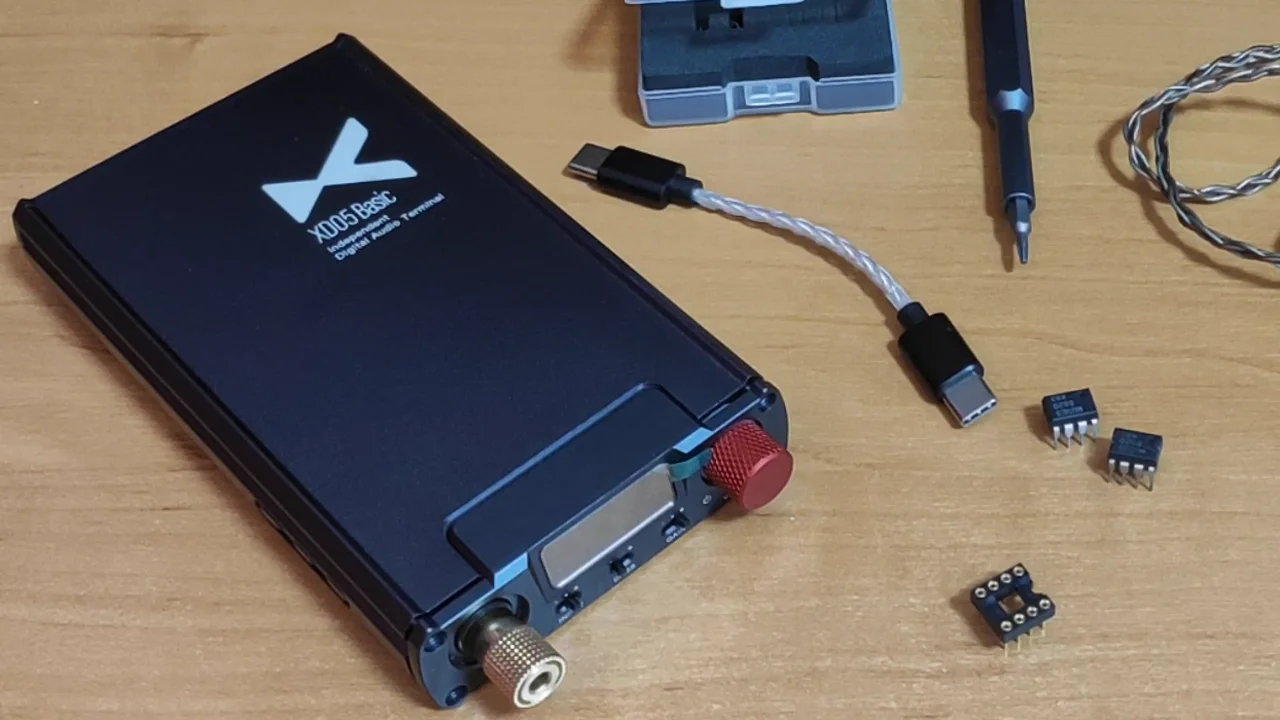 xDuoo XD-05 Basic на столе: красная ручка громкости, золотой разъём для наушников, рядом кабель USB-C и операционные усилители